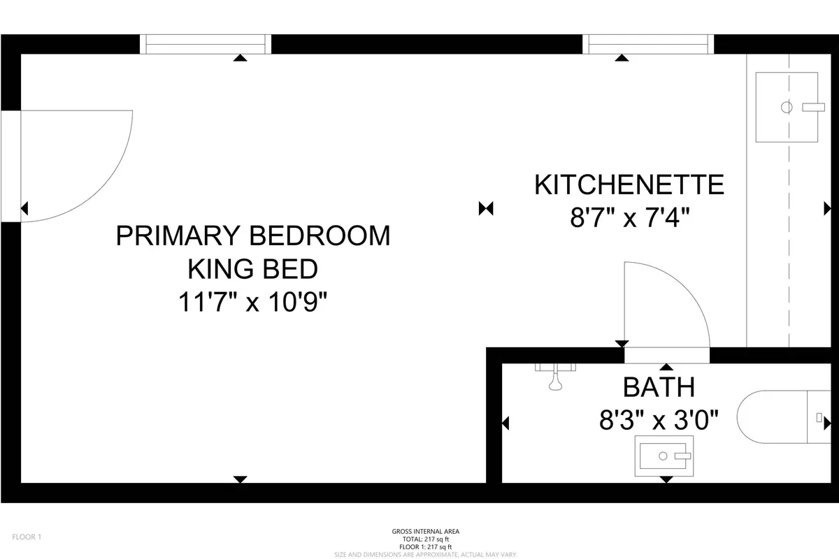 This image highlights a cohesive interior setting featuring the primary bedroom with a view toward the kitchenette and bath. The kitchenette area is compact but functional, equipped for preparing simple meals or a cozy dinner in. The visual linkage between sleeping and cooking areas emphasizes the convenience and intimacy of in-room dining.